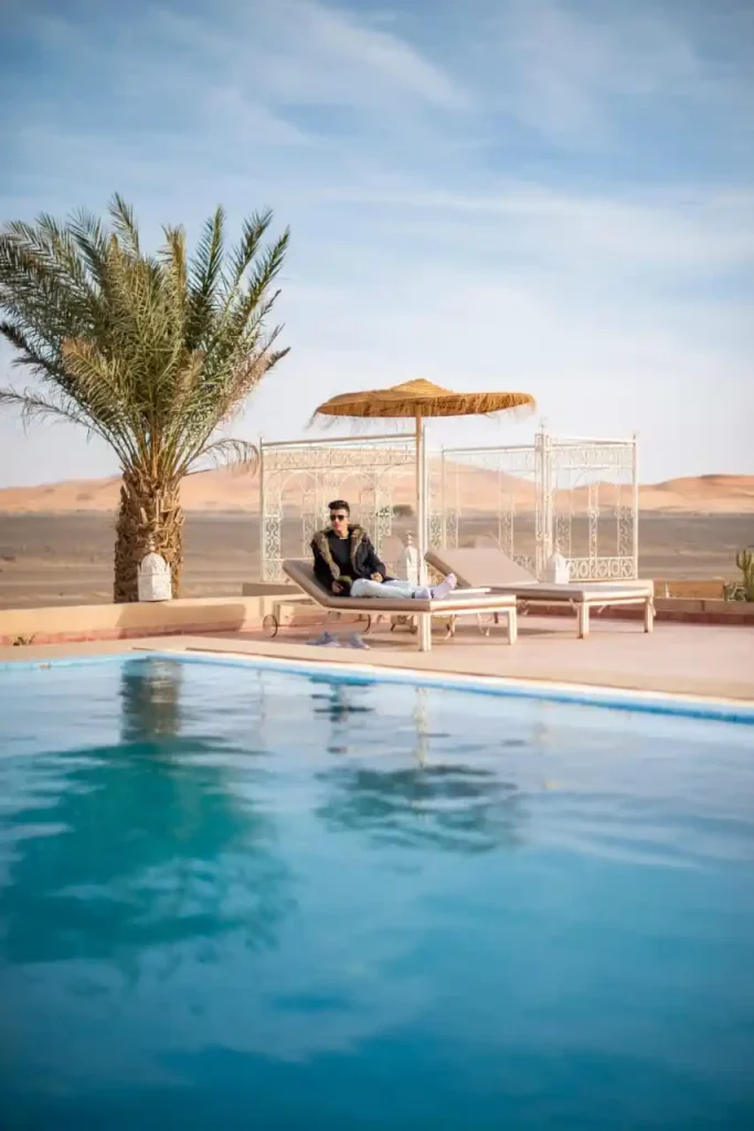 Man lounging by desert pool.